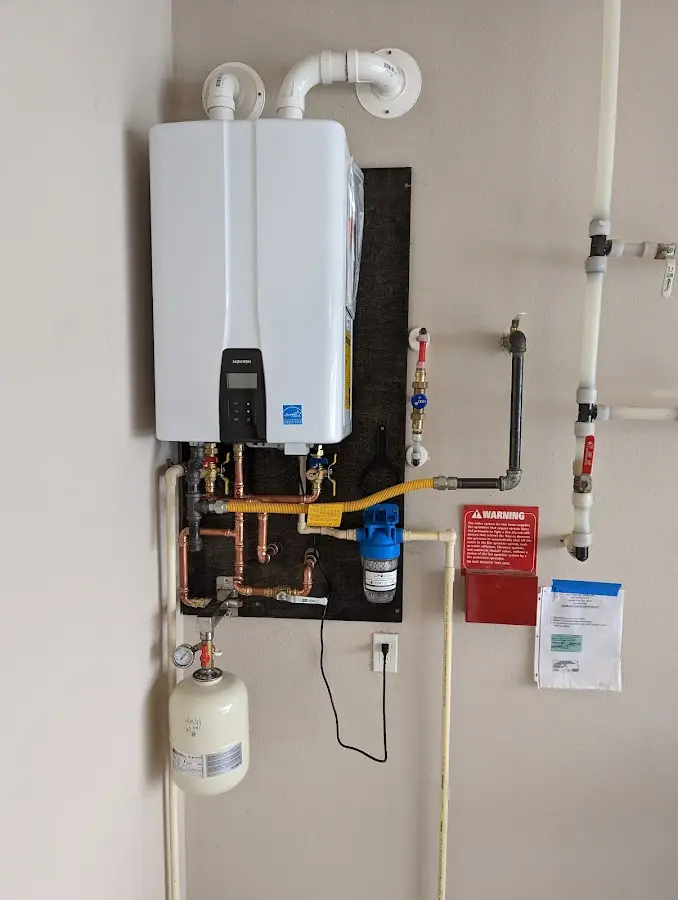 Professional plumber installing copper piping in a Tice home